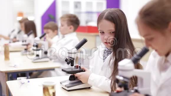 小学生们看显微镜现代教育的主题视频的预览图