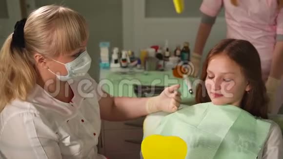 牙医向少女病人解释一些事情与孩子一起工作视频的预览图