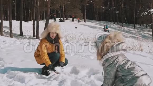 家庭在阳光明媚的冬日户外玩得很开心妈妈和女儿玩雪视频的预览图
