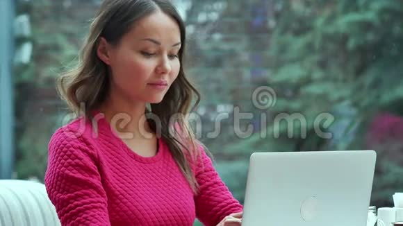 千禧年的年轻女性在咖啡馆里用笔记本电脑在线聊天视频的预览图