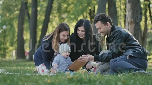 年轻的瑞典家庭与小男孩在公园的封面上放松视频的预览图