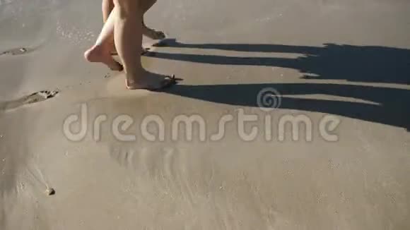 两个赤脚的女孩在海边散步视频的预览图