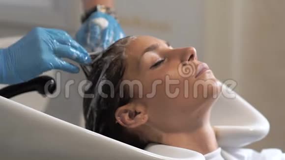 造型师在理发店洗了一个女人的头视频的预览图
