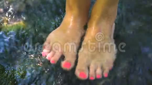 赤足女子用湍急的河水在水中溅起双腿视频的预览图