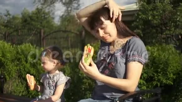 妈妈和小女儿在户外吃热狗视频的预览图