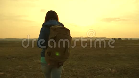 旅游的年轻女子去山上看日落一个背着背包在天空中旅行的女孩视频的预览图