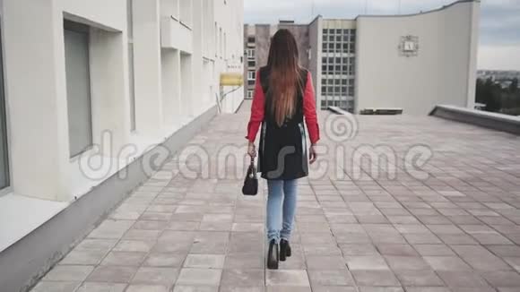 迷人的女孩走在一个城市的街道上而不是转向相机和微笑视频的预览图