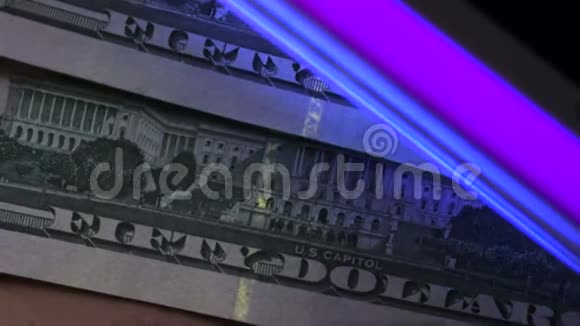 关闭扫描美元钞票在紫外线下的镜头视频的预览图