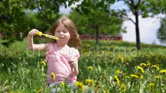 春天阳光明媚的日子里小可爱的女孩在玩蒲公英视频的预览图