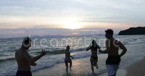 在夕阳下的海滩上的人们在海上奔跑在度假中欢送欢乐的朋友视频的预览图