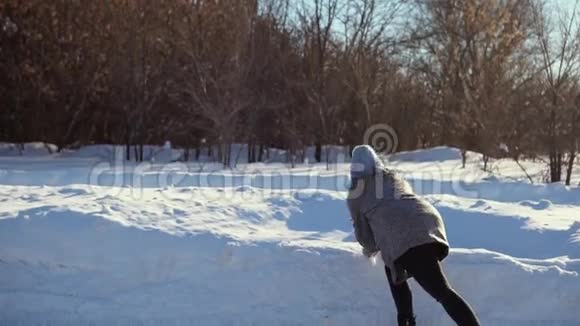 冬天森林里玩雪球的年轻漂亮女人视频的预览图