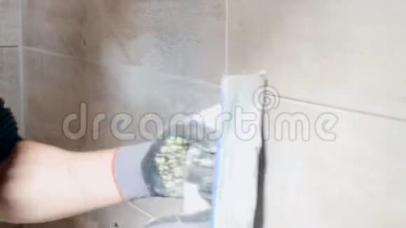 男人手把米黄色瓷砖的接缝放在墙上关门视频的预览图