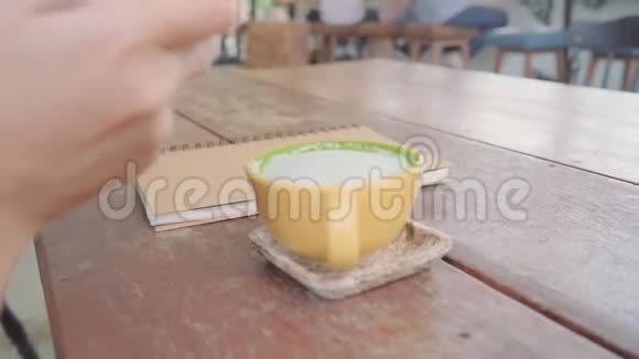 女博主用手机在咖啡馆里拍摄绿茶一位年轻女子在智能手机上拍咖啡茶视频的预览图