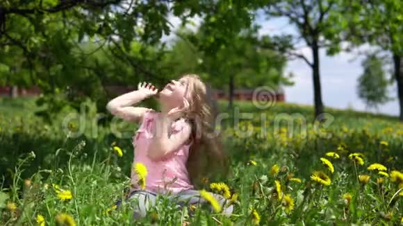 春天阳光明媚的日子里小可爱的女孩在玩蒲公英视频的预览图