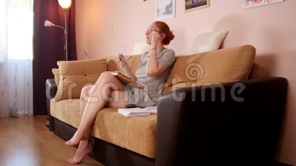 坐在沙发上选择眼镜的女人视频的预览图