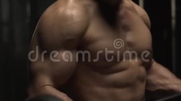 肌肉发达的运动型男子赤裸的躯干在健身房用杠铃锻炼视频的预览图