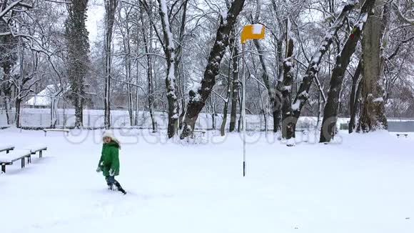 女孩把雪球扔到篮球圈里冬天下雪玩游戏视频的预览图