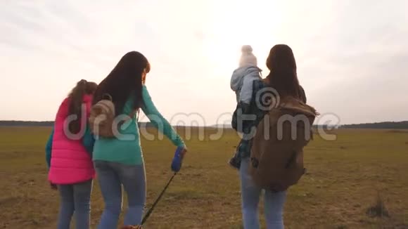 妈妈小孩女儿和宠物游客一家人和狗在平原上旅行紧密结合的团队合作视频的预览图