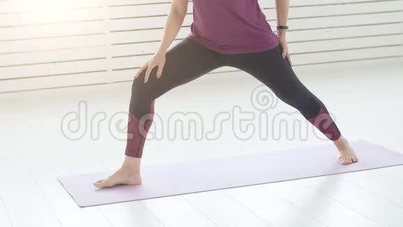 和谐体育和健康的概念中年妇女在白色的室内做瑜伽视频的预览图