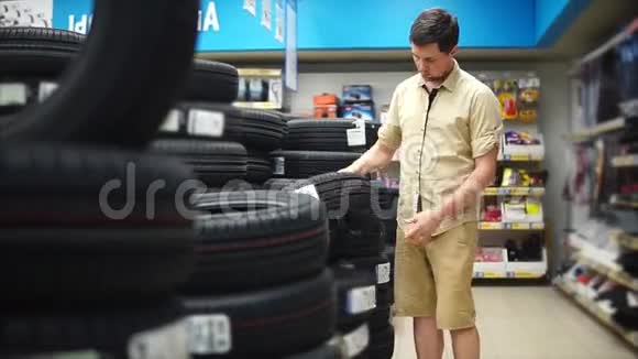 汽车爱好者在商场里为他的汽车选择轮胎仔细观察视频的预览图