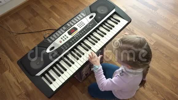 孩子的手在钢琴键盘顶部的视图视频的预览图