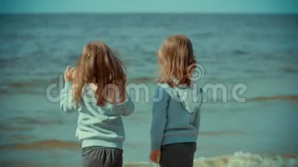 夏天两个女孩站在沙滩上的水里视频的预览图