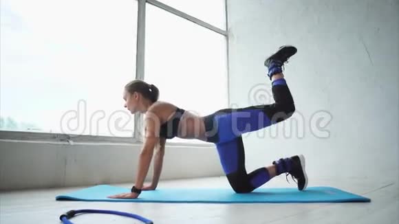 漂亮而运动的女孩用脚做一个秋千以加强臀部视频的预览图