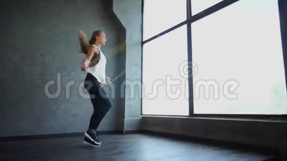一个有魅力的运动女孩跳绳她从事有氧运动视频的预览图