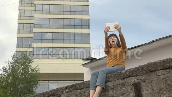 女人在屋顶的边缘使用平板电脑视频的预览图