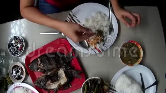 亚洲餐馆里赤手空拳吃鱼的女人视频的预览图