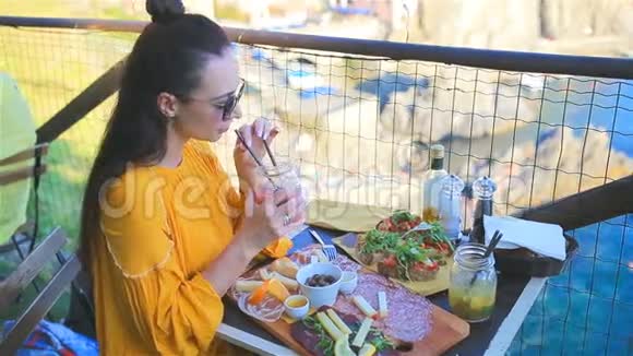美丽的女士在室外咖啡厅享用早餐在CinqueTerre的Manarola美景令人惊叹视频的预览图