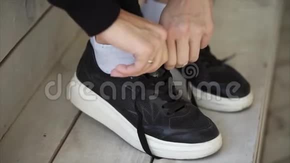 女人的脚穿黑色运动鞋手系鞋带特写视频的预览图