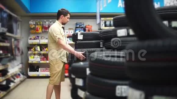 汽车爱好者在商场里为他的汽车选择轮胎仔细观察视频的预览图