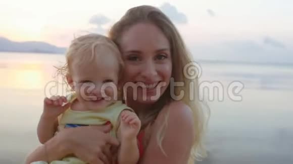 快乐的母亲和她的孩子在海边视频的预览图