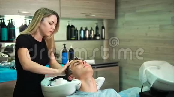 金发发型师用来美容院的洗发精洗头视频的预览图