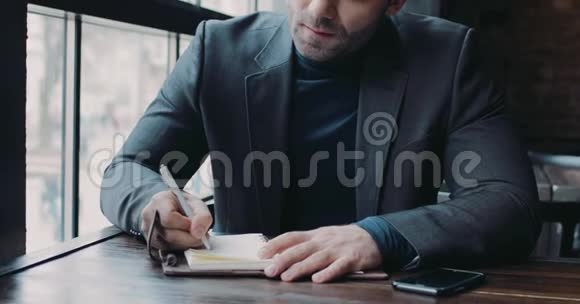 一位严肃的商人在咖啡馆A签署文件的男性肖像正式的服装积极的生活方式成功的生活视频的预览图