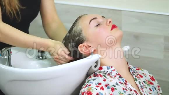 理发师为一位来美容院的漂亮女人洗头视频的预览图