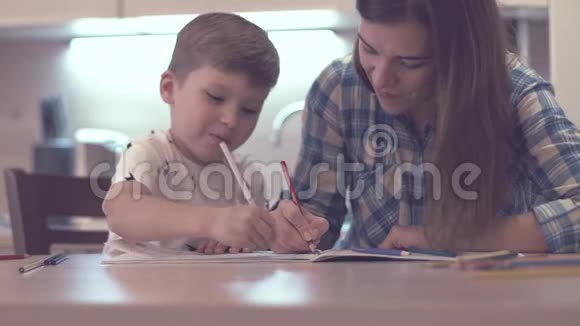 小男孩和美丽的母亲一起画画视频的预览图