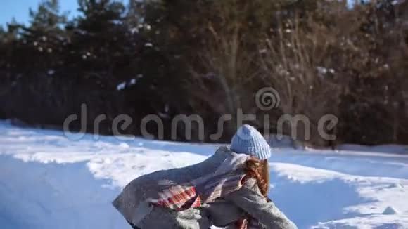 一个年轻的女孩在阳光明媚的冬日里玩得很开心视频的预览图