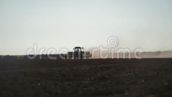 拖拉机耙地的全景农用拖拉机播种和耕作田拖拉机在田间作业视频的预览图