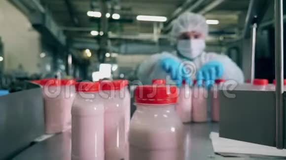 带酸奶的瓶子在工厂的传送带上移动视频的预览图