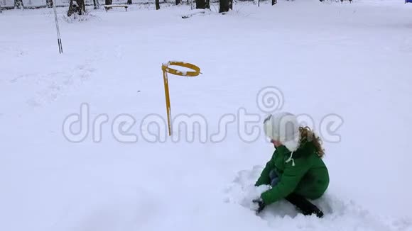 快乐可爱的女孩在冬天玩雪球冬天下雪玩游戏视频的预览图