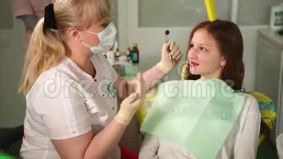 牙医和年轻病人交谈去看牙医的小女孩视频的预览图