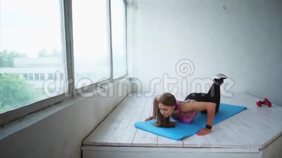 年轻的健身女子做困难的俯卧撑健身房里的场景视频的预览图