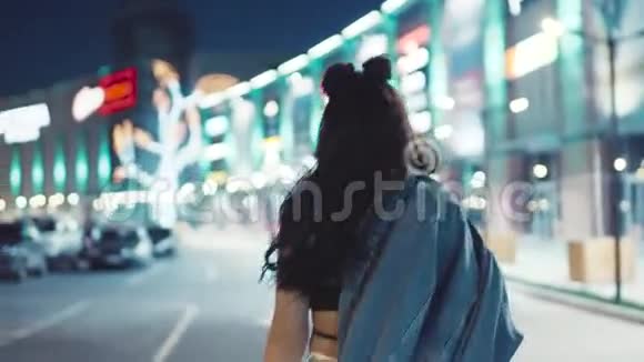 年轻漂亮的女孩穿着红唇在夜城里好奇转向相机给人一种迷人的感觉视频的预览图