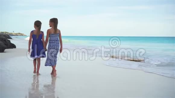 小女孩在白色海滩上海边散步晚上孩子们在海滩度假视频的预览图