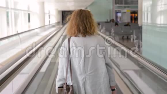 机场的女女孩从后面的生姜头发上移动皮带视频的预览图