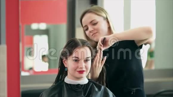 一位发型师正在梳湿头发以便用吹风机吹干头发视频的预览图