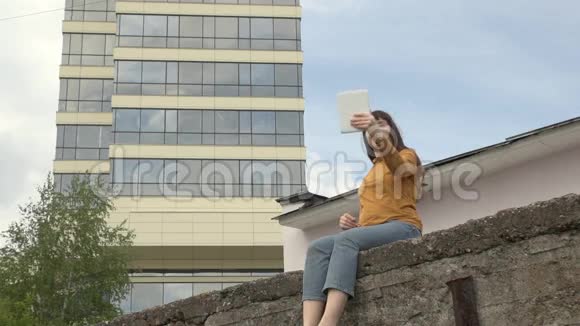 女人在屋顶的边缘使用平板电脑视频的预览图