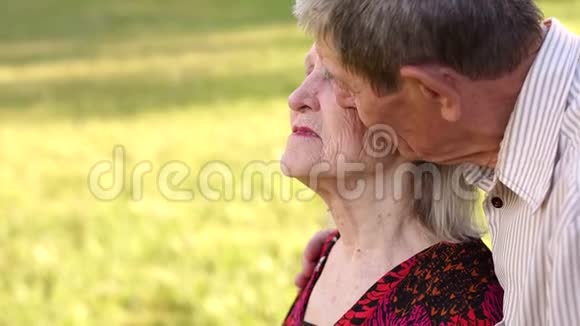 一位祖父在公园亲吻他的妻子视频的预览图